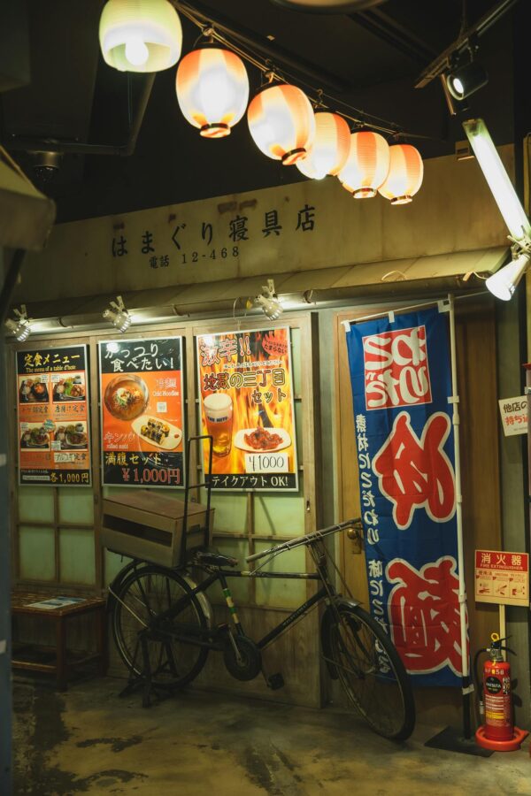 Shining Chinese lanterns above bike parked near cafe